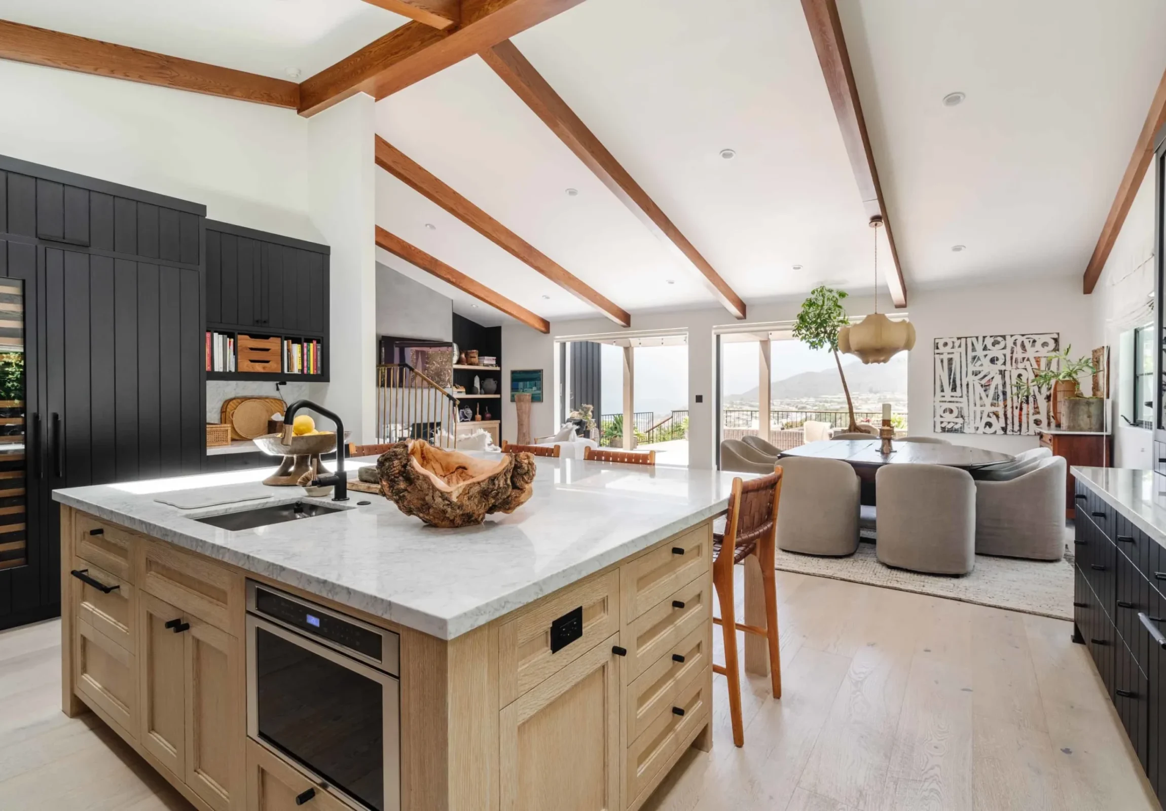 Open-plan kitchen and living room with a vaulted beamed ceiling and ocean view